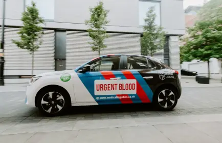 A branded medical logistics electric car with the inscription urgent blood
